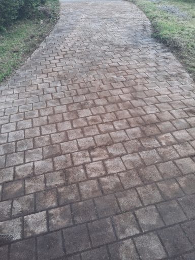 Pflasterweg mit rechteckigen Steinen in verschiedenen Brauntönen.